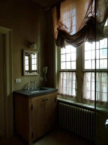 a bathroom with a sink and two windows at B&B Saint-Sauveur Bruges in Bruges