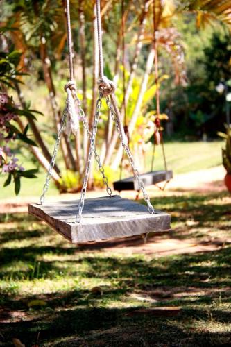 two swings in a park with grass and trees at Quinta da Bocaina in Amparo