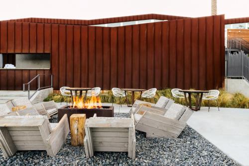 a patio with chairs and a fire pit and a fence at ARRIVE Palm Springs - Adults Only in Palm Springs