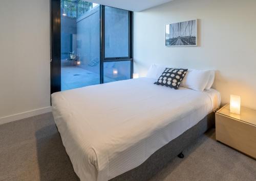 a bedroom with a large bed and a window at Melbourne City Apartments - Teri in Melbourne