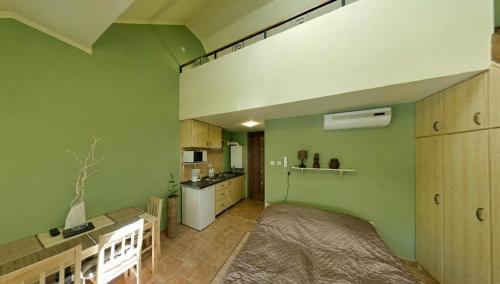 a bedroom with a large bed and a kitchen at Maja Apartman in Gyula