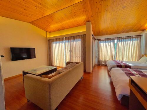 a bedroom with two beds and a couch and a tv at 瑞穗六心居 in Ruisui