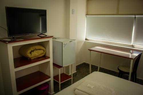 a small kitchen with a refrigerator and a tv at WISZ-V in Belén