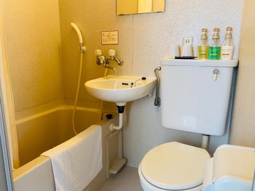 a white toilet sitting next to a sink in a bathroom at Sakura Hotel Hatagaya in Tokyo