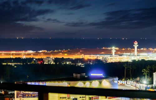 a view of a city at night with a water tower at Ventimo Hotel & Residence Jeju in Jeju