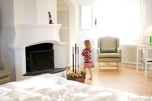 a little girl standing in a living room with a fireplace at Hooks Herrgård in Hok