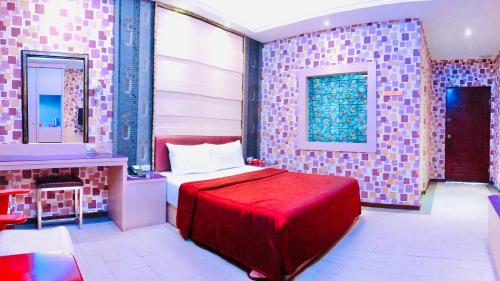 a bedroom with a red bed and a mirror at 楓情汽車旅館 in Pingtung City