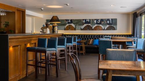 a bar with blue chairs and tables in a restaurant at Hotel Montreal in Christchurch