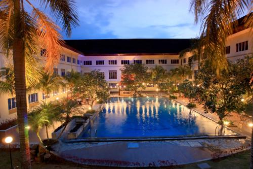 a large pool in the middle of a building with palm trees at ASTON Tanjung Pinang Hotel & Conference Center in Tanjung Pinang 