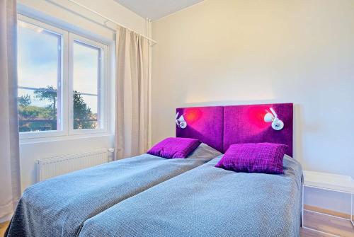 a bedroom with a bed with a purple head board at Holiday Club Saariselkä Superior Apartments in Saariselka