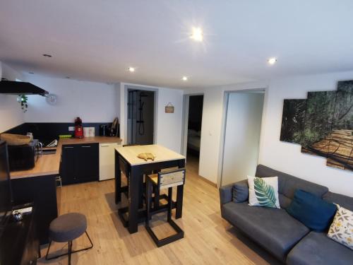 a living room and kitchen with a couch and a table at Gîte 2 chambres avec piscine in Sernhac