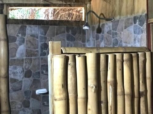a wooden fence in a room with a stone wall at Moringa Ingadi in Treasure Beach
