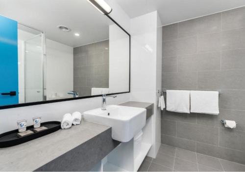 a white bathroom with a sink and a mirror at Alloggio Thornton in Maitland