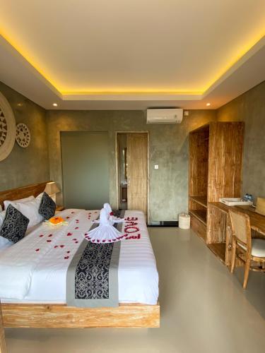 a bedroom with a large bed and a desk at Goutama Homestay in Ubud
