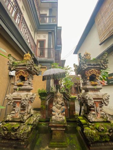 a building with two statues in front of it at Goutama Homestay in Ubud