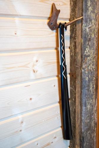 a black umbrella hanging on a wooden wall at Ylläksen Yöpuu in Äkäslompolo