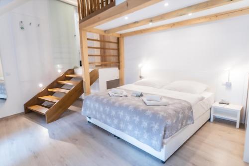 1 dormitorio con 1 cama grande y escalera de madera en Erhardt Panzió en Sopron