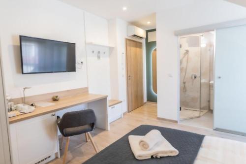 a bathroom with a shower and a sink and a chair at Erhardt Panzió in Sopron