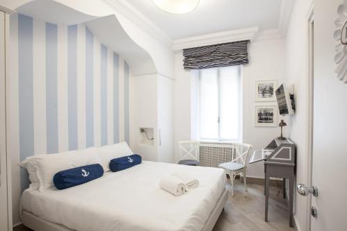 een slaapkamer met een wit bed en een bureau bij Hotel Marina Charming Rooms in Finale Ligure
