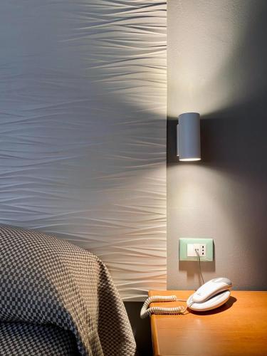 a telephone on a night stand next to a bed at Hotel degli Amici in Artena