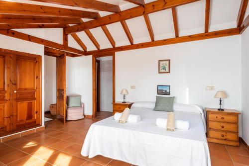 Un dormitorio con dos camas en una habitación con techos de madera. en Villa Carolina, en Son Bou