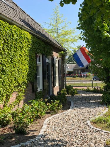 a house with a flag on the side of it at B&B Mir Lo in Mierlo Adults only in Mierlo
