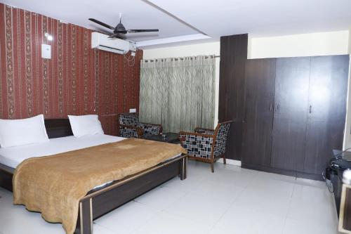 a bedroom with a bed and a ceiling fan at Hotel Maruthi Residency Inn L B Nagar in Surūrnagar