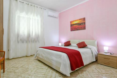 1 dormitorio blanco con 1 cama con manta roja en Green Paradise Holidays villa Apartment, en Massa Lubrense