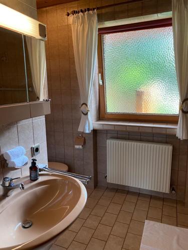 ein Bad mit einem Waschbecken und einem Fenster in der Unterkunft Ferienwohnung an der Familienabfahrt in Brixen im Thale