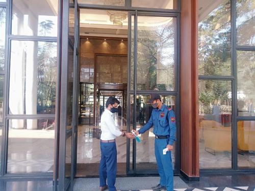 two men shaking hands in front of a building at Hotel Polo Towers Agartala in Agartala