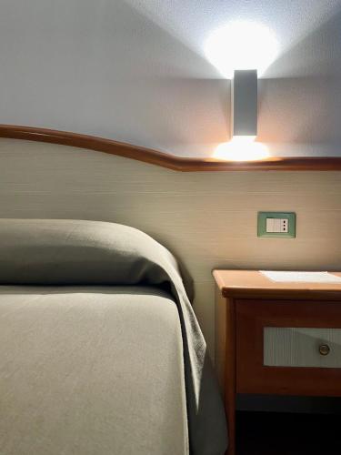 a bedroom with a bed and a light on the ceiling at Hotel degli Amici in Artena