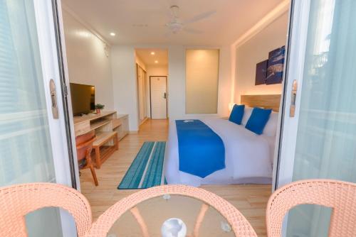 a bedroom with a bed and a desk and a television at Dhiguveli Maldives in Dhigurah