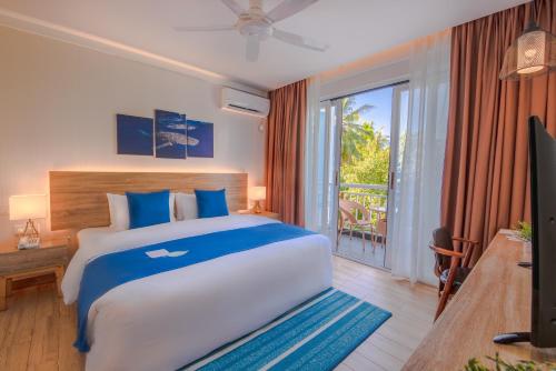 a bedroom with a large bed and a balcony at Dhiguveli Maldives in Dhigurah