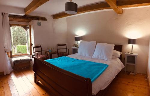 a bedroom with a large bed with a blue blanket at Trevejean chambre d'hotes de charme in Guerlédan