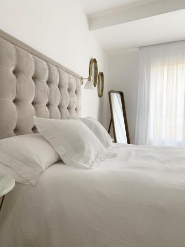 a bed with white sheets and pillows in a bedroom at Casa Condes de Gómara in Soria