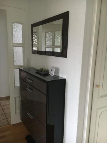 a bathroom with a dresser and a mirror on the wall at Hotellerie Gasthaus Schubert in Garbsen