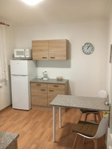 a small kitchen with a table and a refrigerator at Hotellerie Gasthaus Schubert in Garbsen