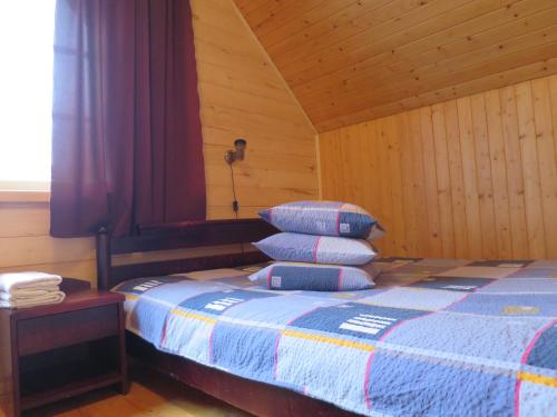 a bedroom with a bed with two pillows on it at Männi Farm Holiday House in Eoste