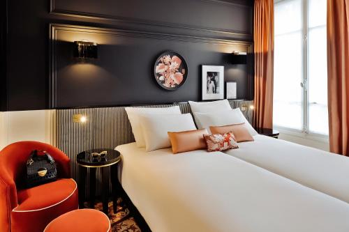 a bedroom with a large white bed and a red chair at Mercure Paris Gare De Lyon Opera Bastille in Paris