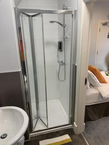 a shower with a glass door next to a sink at Muir Bank in Muir of Ord