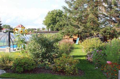 a garden with flowers and a playground in the background at Apartment Dream in Františkovy Lázně