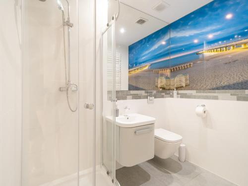 een badkamer met een douche, een toilet en een wastafel bij ApartmentyPrzyMorzu Ogrody in Kołobrzeg