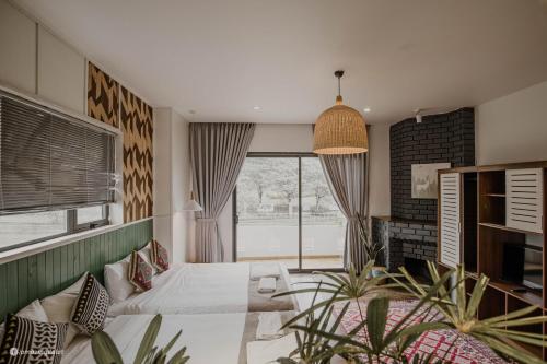 a bedroom with a bed and a large window at The Scent Boutique Dalat Hotel in Da Thien