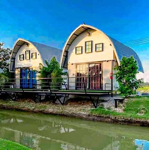 a large building with a dome next to a river at ข้าวทุ่งเบ็ญจาโฮมสเตย์ in Ban Hat Phang