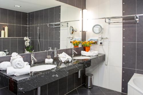 a bathroom with two sinks and a mirror at City Hotel Roding in Roding