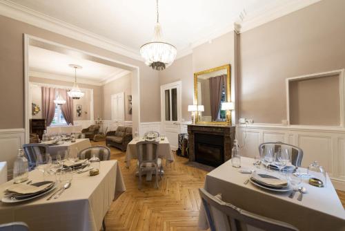 a dining room with two tables and a fireplace at Domaine Les Tilleuls in Wailly-Beaucamp