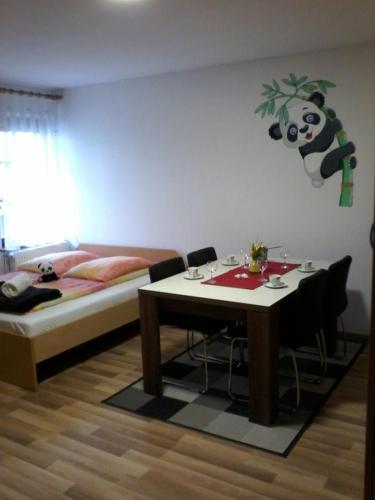 a bedroom with a bed and a table with a panda on the wall at Apartment Panda in Dolenjske Toplice