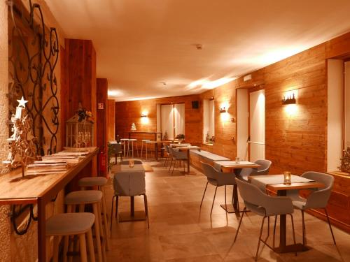 un ristorante con pareti e tavoli in legno e sedie di Hotel Paradiso ad Asiago