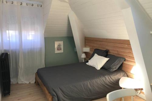 a bedroom with a large bed with a wooden headboard at Maison Chiche in Bain-de-Bretagne