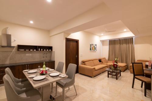 a living room with a table and chairs and a couch at Mojatel By Icon in Bengaluru